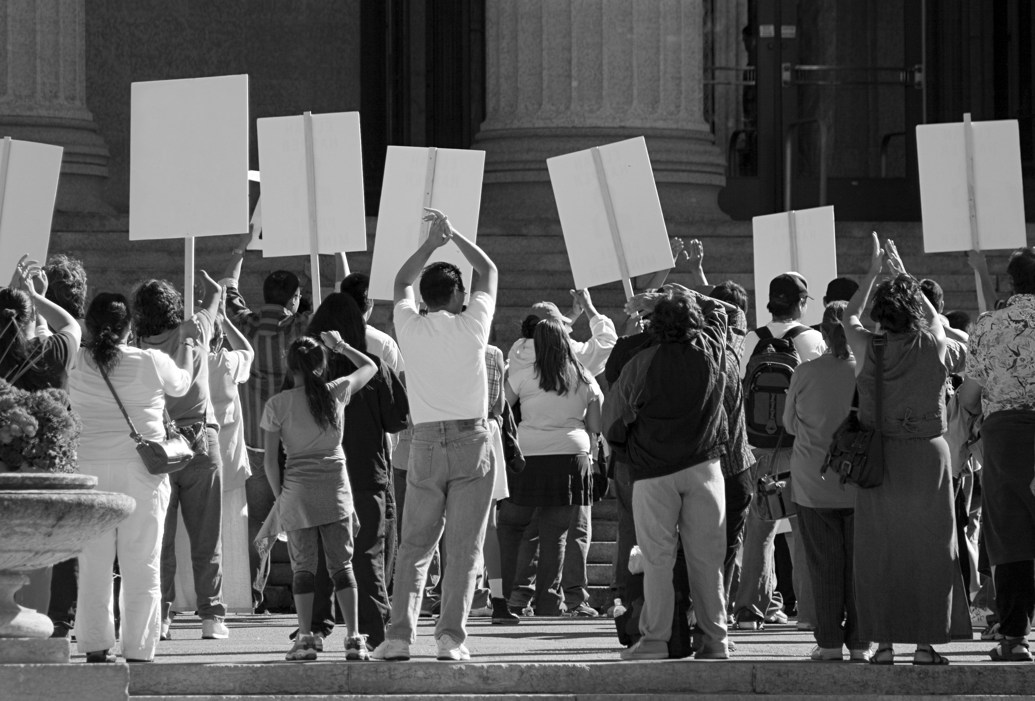 Black-and-white photo of a crowd holding protest signs, used as a 'battle for the internet' blog header.